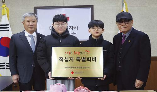 손자 손잡고, 22년째 저금통 들고 적십자를 찾는 가족 손자 손잡고, 22년째 저금통 들고 적십자를 찾는 가족